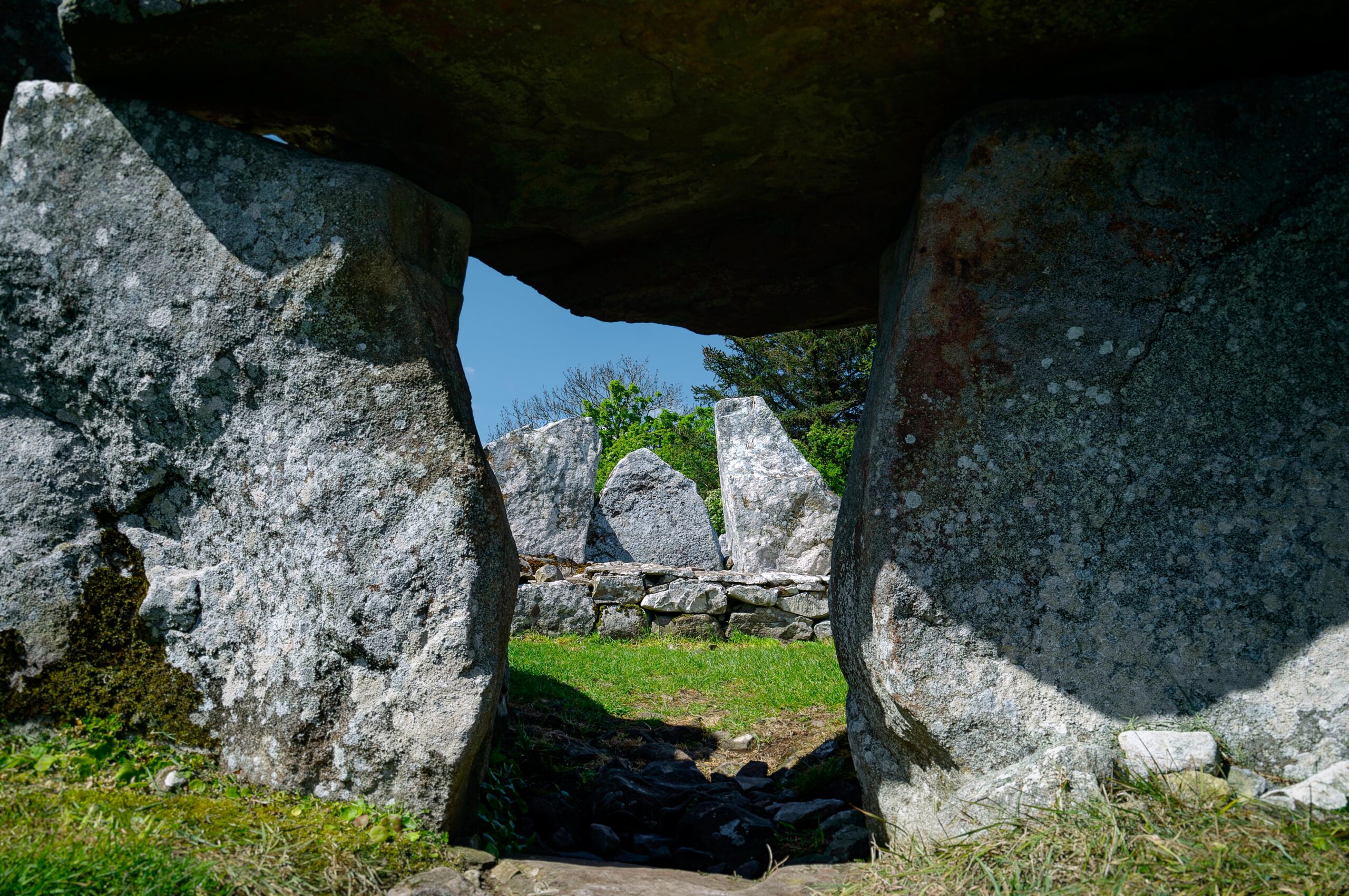 a stone archway with grass and rocks